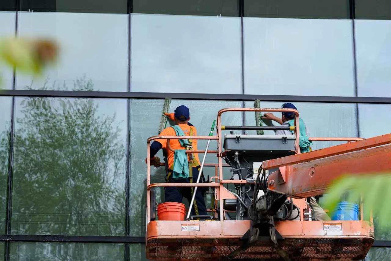 Team cleaning office windows from a lift