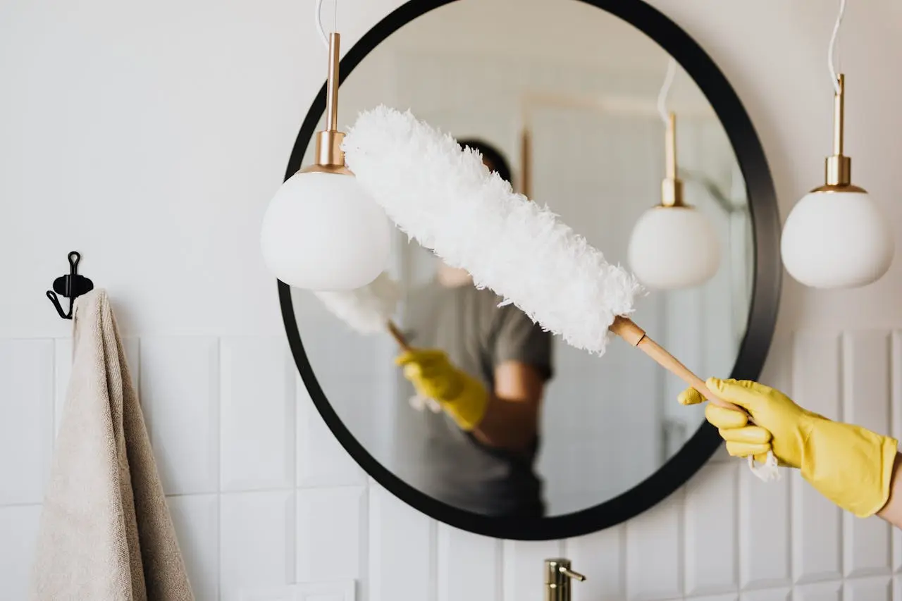 Cleaner dusting a round mirror