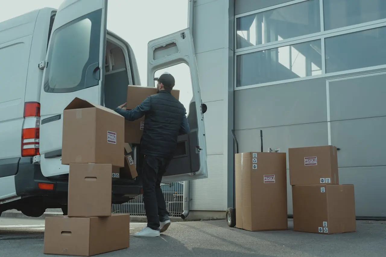 Movers carrying boxes into a van